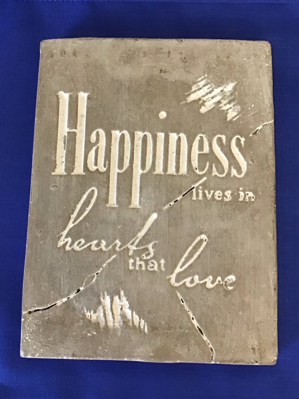 Distressed concrete love quote plaque sign. Happiness lives in hearts that love